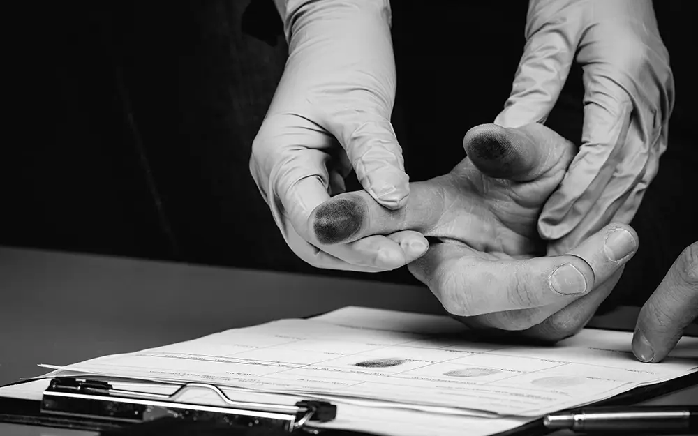 Photo showing someone getting fingerprinted after being arrested